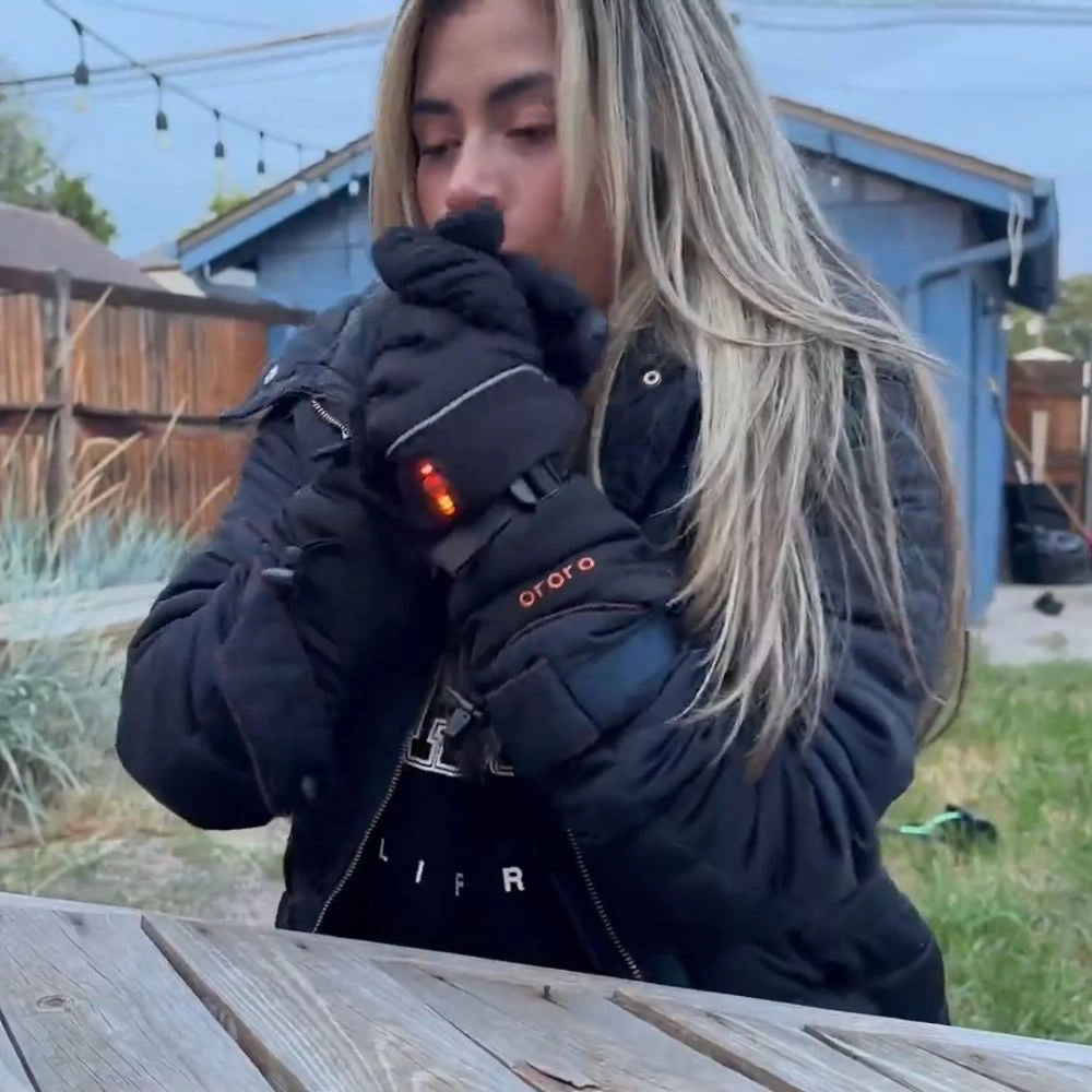 Person wearing a black jacket and gloves outdoors, with a blurred background