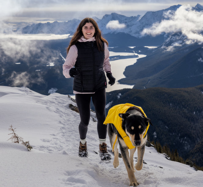 10 Year Story | Woman and dog hiking in a snowy mountain landscape